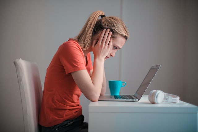 Homeschool Mom looking at computer about to cry about the hardest part of homeschooling