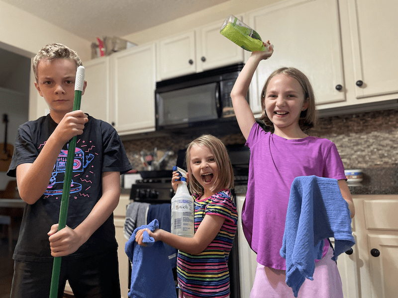 happy kids managing housework with cleaning supplies