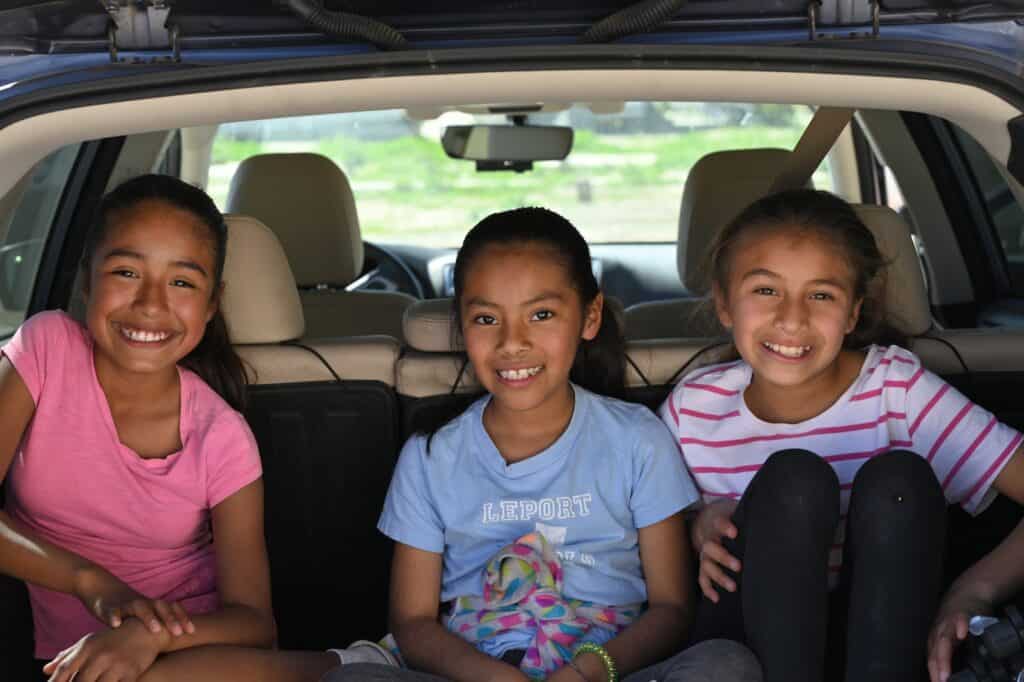 three girls smiling in vehicle