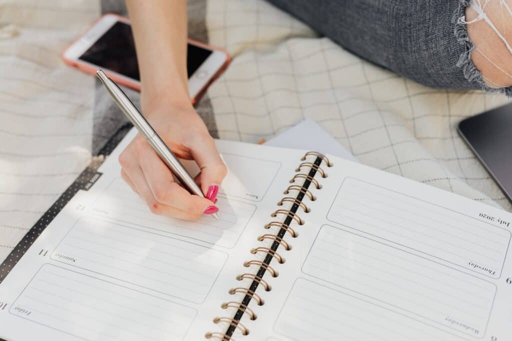 woman writing in a planner. how to use a planner
