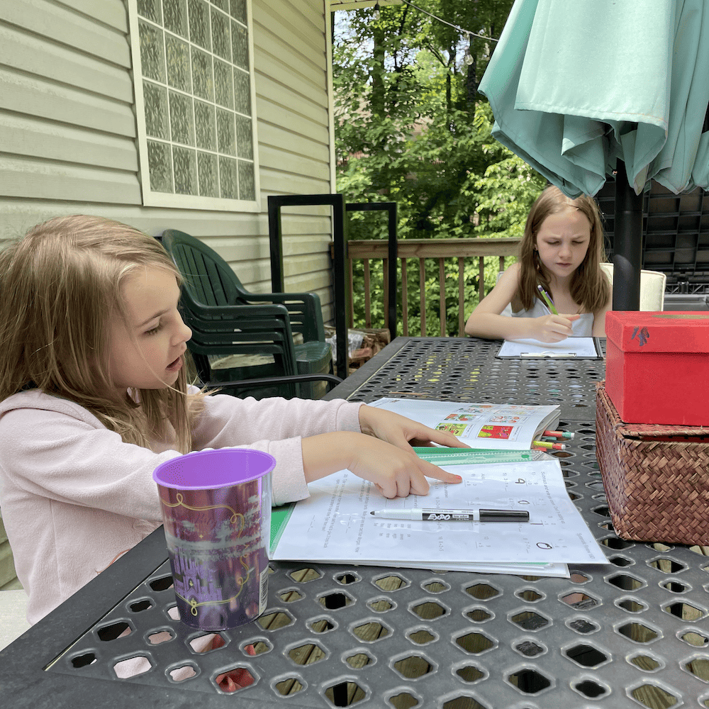 girls doing schoolwork outside