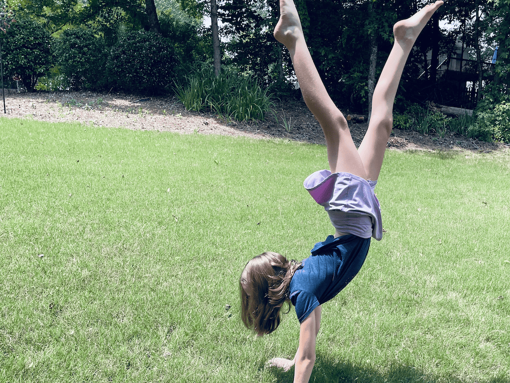 a young girl doing a handstand