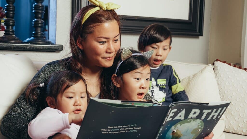mom reading a book with kids called Earth!