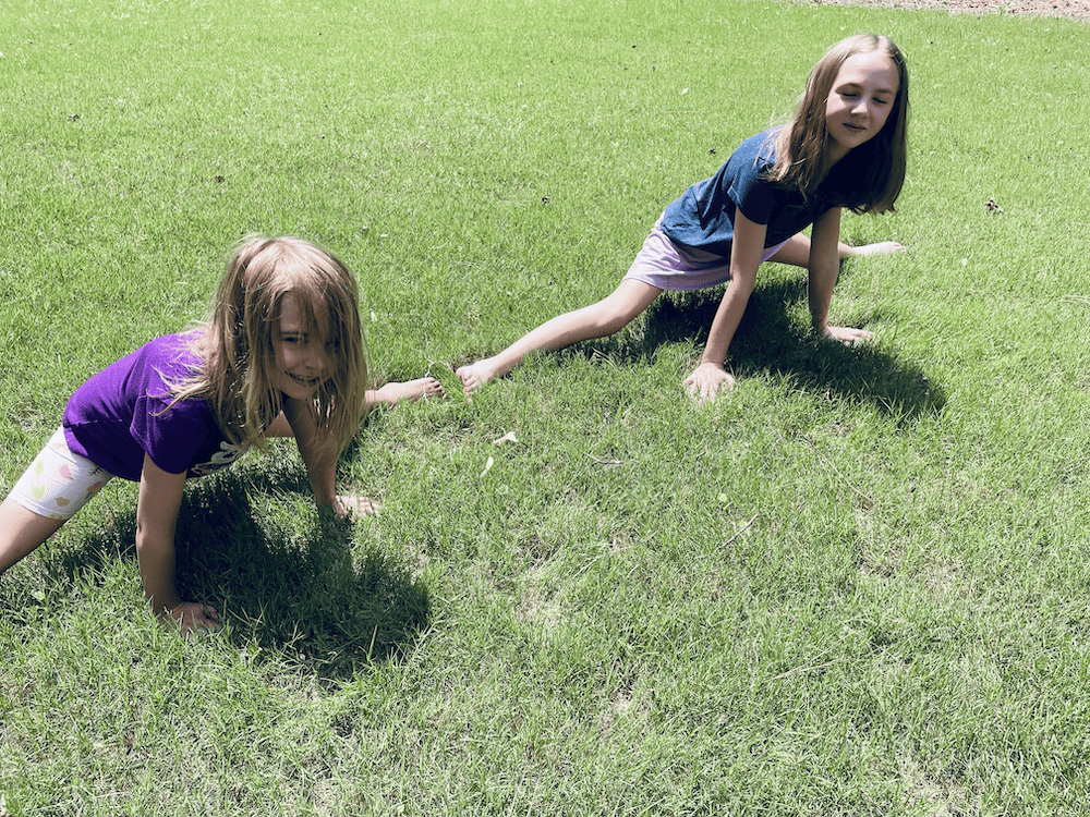 2 young girls doing the splits in the grass. flexible homeschool