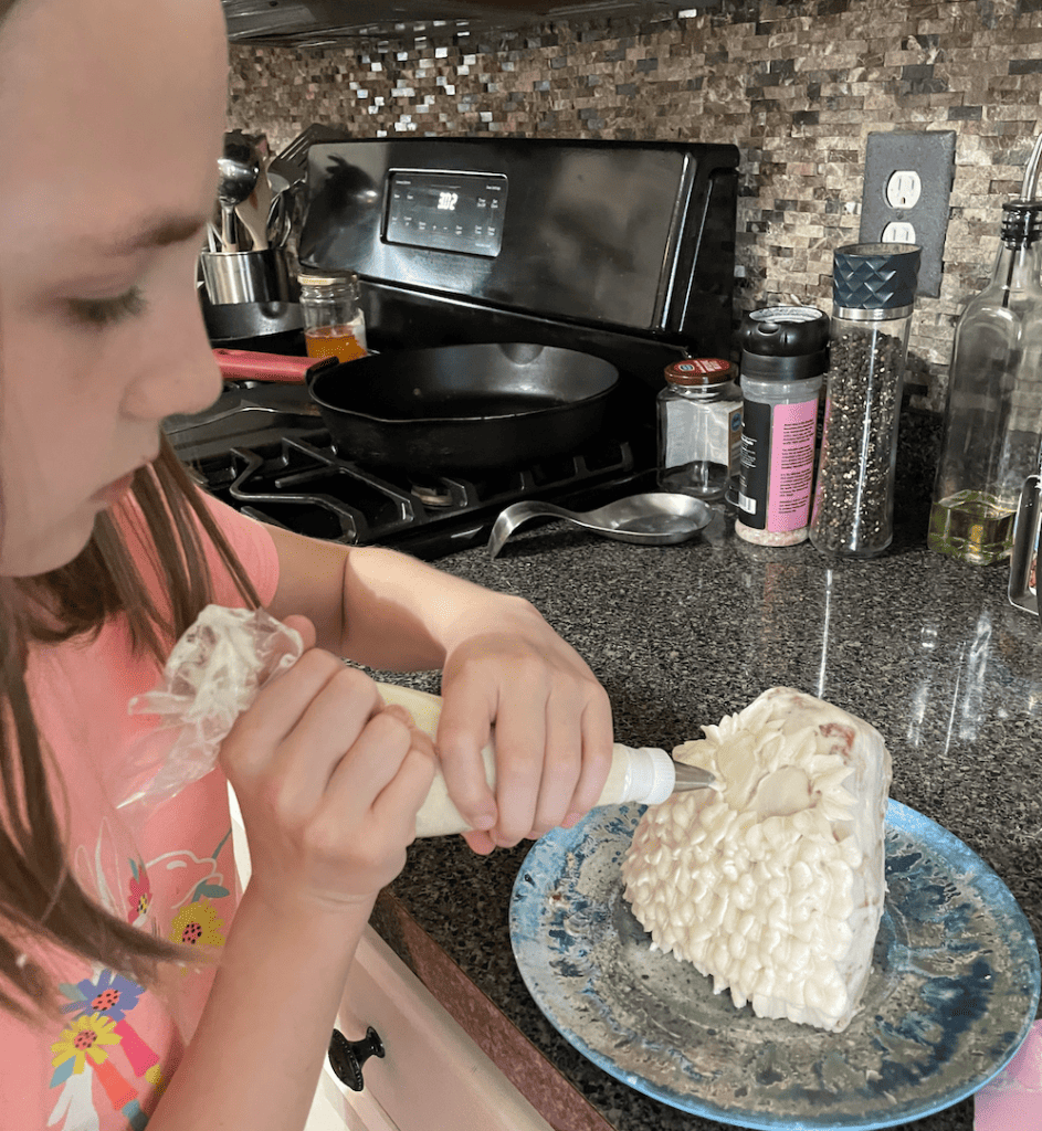 a young girl decorating a small cake