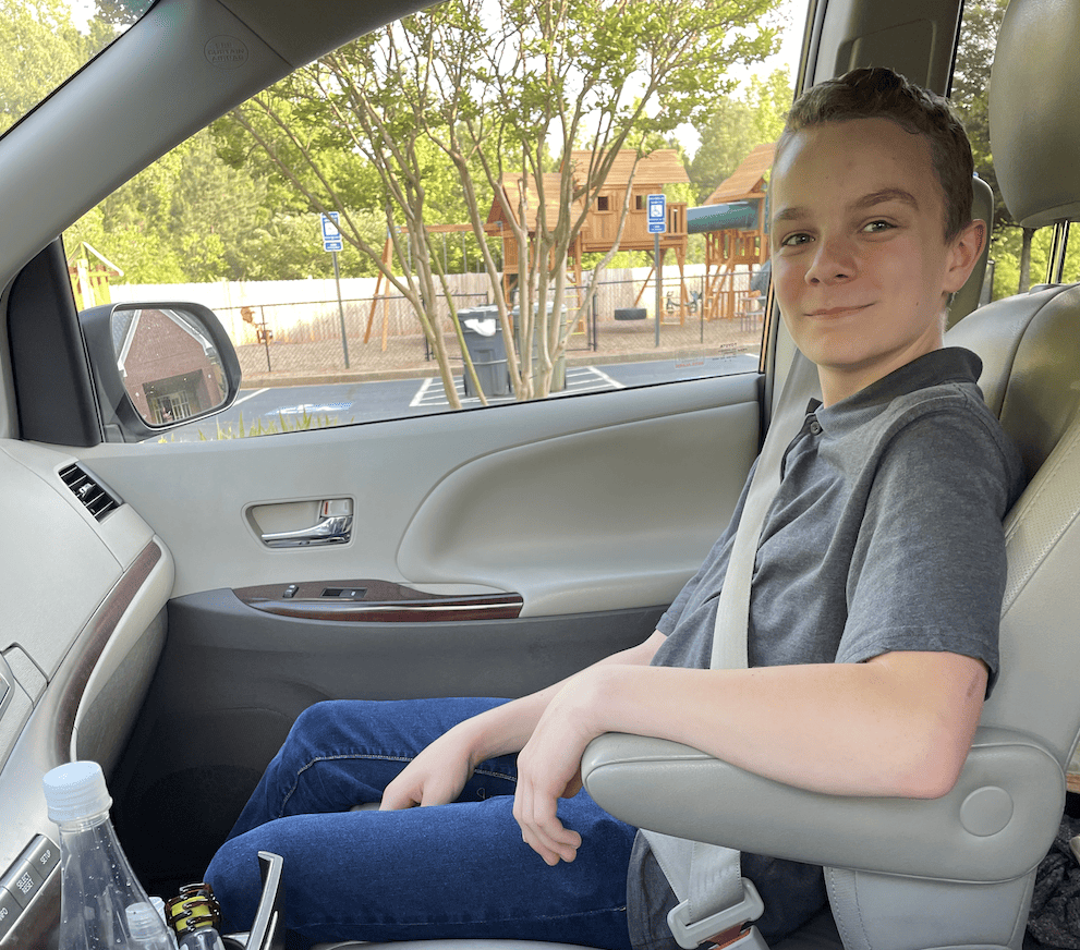 a teen boy sitting in the car