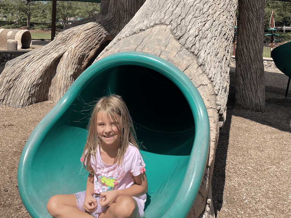 girl at bottom of slide with static hair