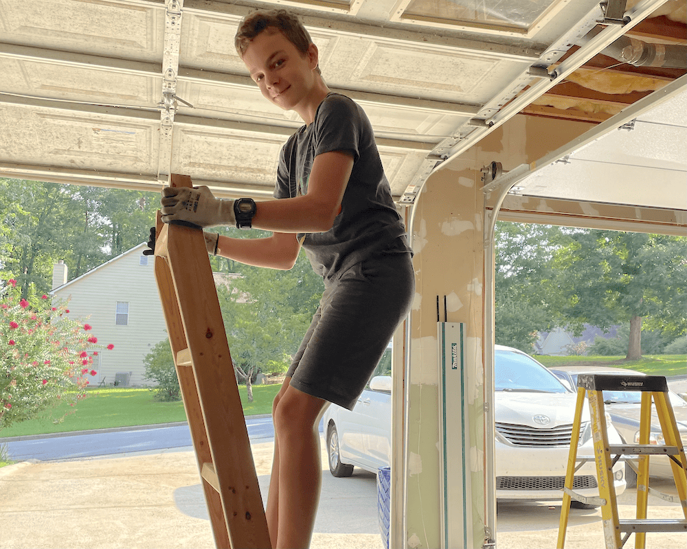 physics lesson in the garage. boy on a ladder to nowhere 