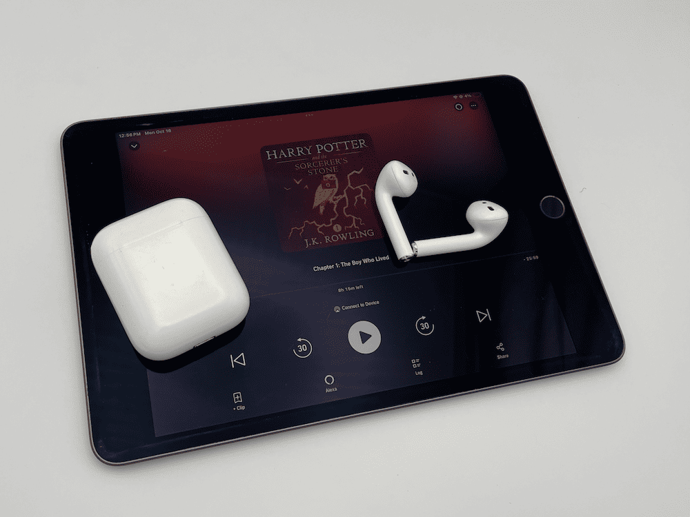 tablet playing an audiobook. AirPods on top