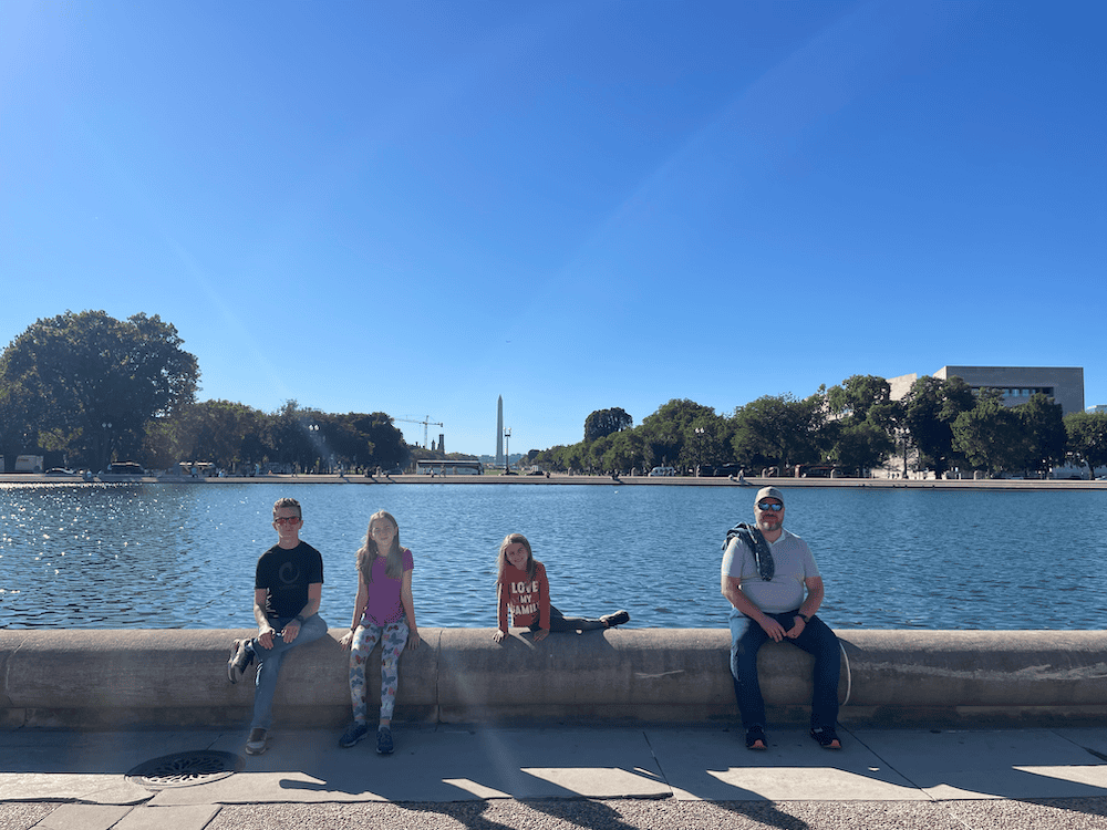 family sitting on a wall in Washington DC with kids