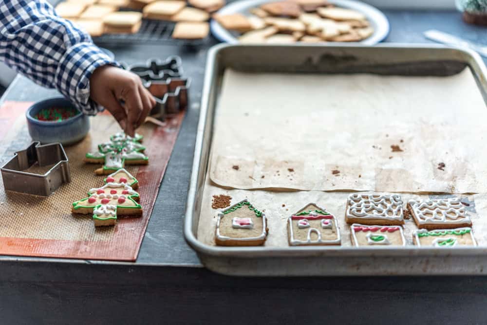 Photo by Anshu A. a person decorating Christmas cookies on a table
